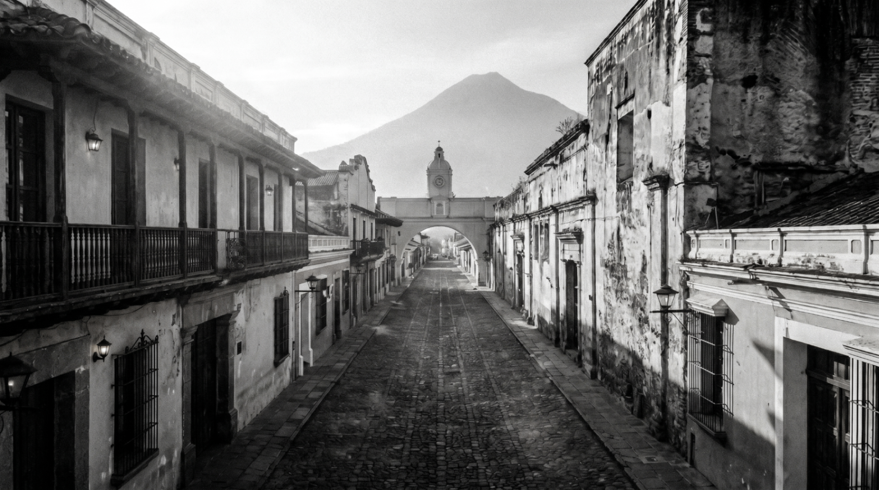 Calle empedrada de Antigua, Guatemala con el Arco de Santa Catalina y el Volcán de Agua al fondo